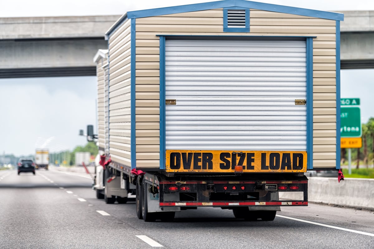 Oversized load trailer hauling a building on the highway